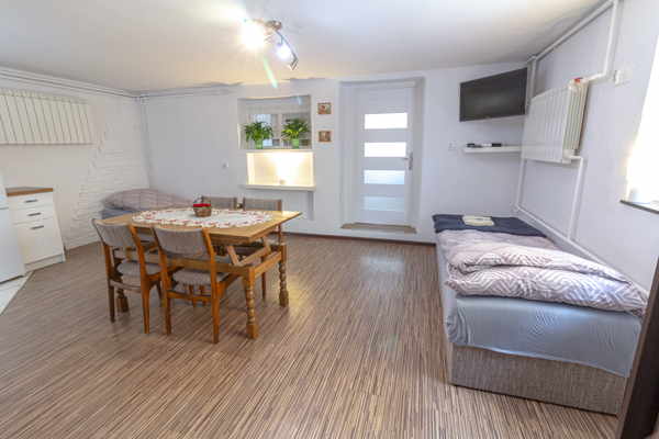 Duży pokój z 3 łóżkami, stołem i aneksem kuchennym